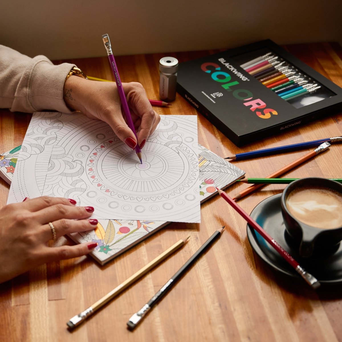 Pessoa colorindo mandala com os lápis Blackwing